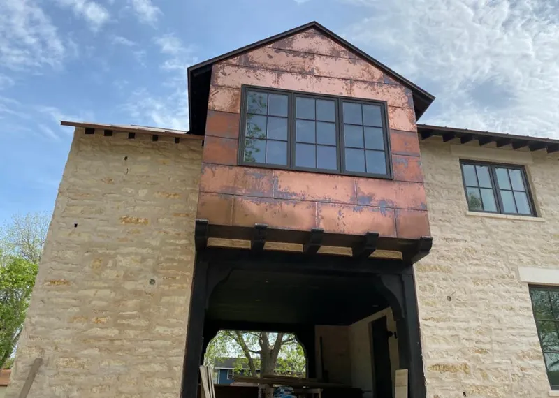 Copper metal panel facade on a stone building for Roof Repair in Cypress Lake